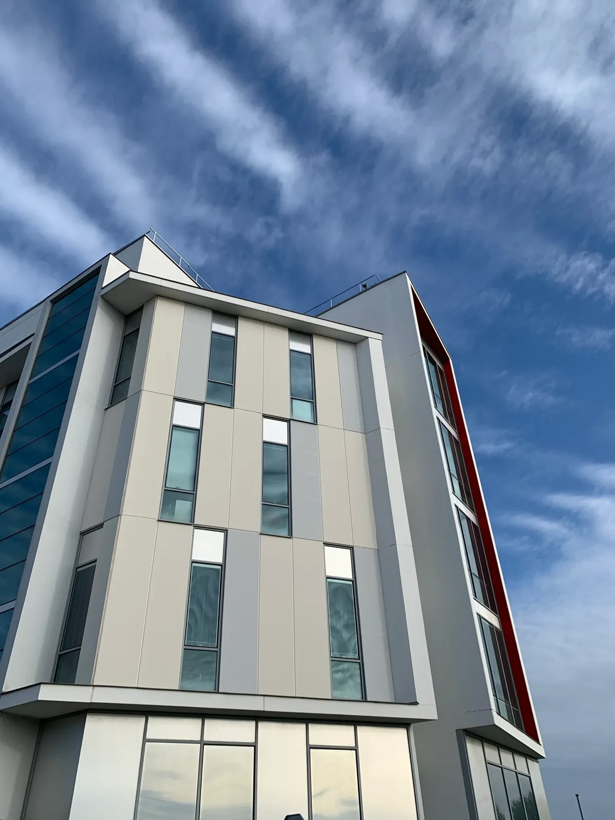 Immeuble de bureaux vu en contre-plongée, le boîtier timelapse est fixé sur la rambarde de toiture et reste invisible depuis la rue